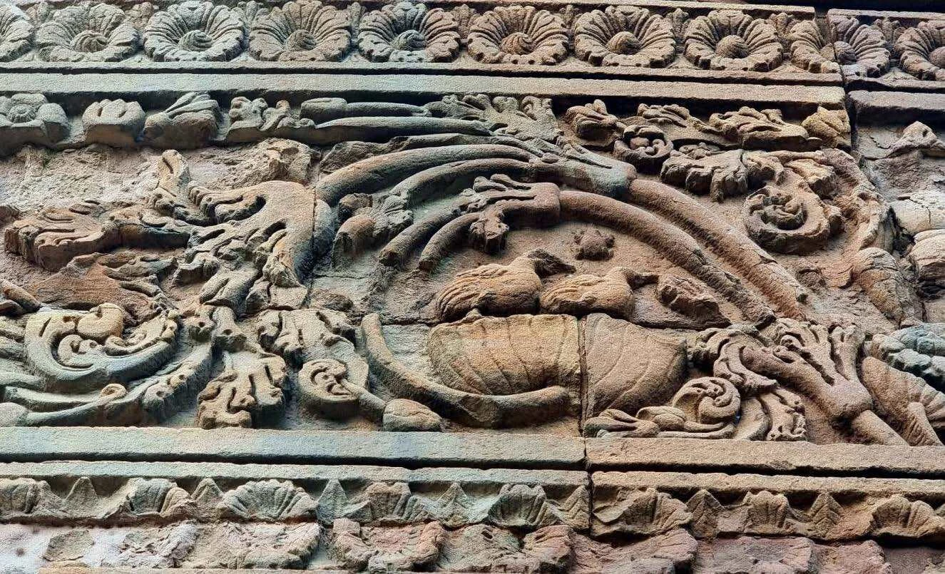 Delaminated stone surfaces along the base plinth of the Dhamek stupa.